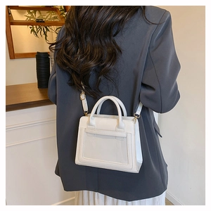 Détail d'un sac à main en cuir PU blanc avec fente frontale transparente et finitions dorées