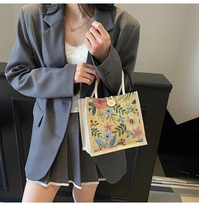 Nahaufnahme der floralen Jacquard-Tasche mit Holzknopf und weißem Seilgriff