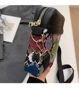 Detail showing colorful snakeskin patchwork and gold metal hardware of the crossbody bag