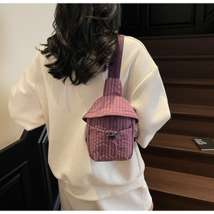 Detail view of purple checkered crossbody bag with adjustable drawstring on a model