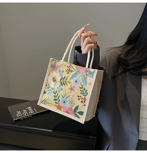 Detail der floralen Canvas-Tasche mit dicken Baumwollseilgriffen und bunter Stickerei