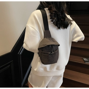 Detail view of the dark checkered crossbody bag with adjustable drawstring closure and strap