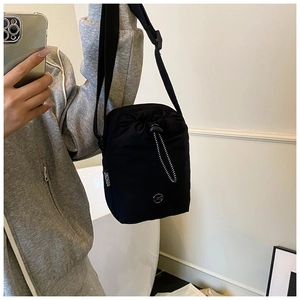Detail of waterproof nylon crossbody bag with drawstring closure and adjustable strap