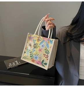 Detail der floralen Segeltuchtasche mit geflochtenen Seilgriffen und Ölgemälde-Blumenmuster
