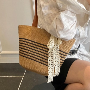 Large striped straw tote bag with brown leather straps and lace bow for beach summer