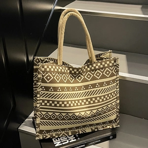 Brown geometric pattern canvas tote bag with woven handles on dark background
