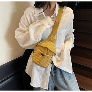 Detail of yellow checkerboard canvas crossbody bag with a functional drawstring front pocket