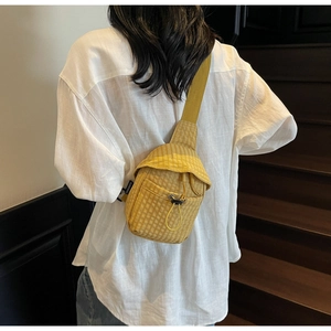 Detail of yellow checkered sling bag with drawstring on a casual crossbody strap