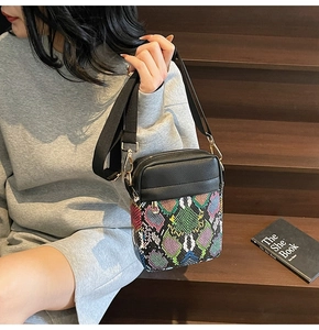 Detail view of the colorful snakeskin pattern and black lychee texture on the crossbody bag