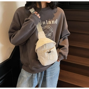 Detail of minimalist cream canvas crossbody bag with textured fabric and drawstring