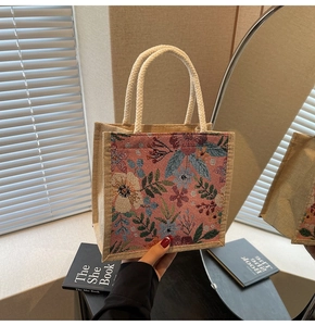 Detail von rosa Blumentapisserie und natürlicher Leinentextur auf einer Retro-Tasche