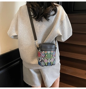 Detail of crossbody bag with color-block snake pattern and wide nylon shoulder strap