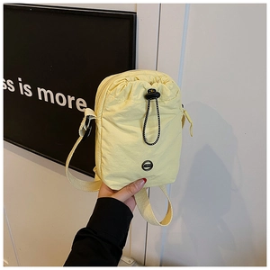 Close-up of lightweight nylon mini crossbody bag with drawstring and zip closure