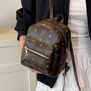 Mini sac à dos marron en similicuir avec motif ours et fermeture dorée porté par mannequin