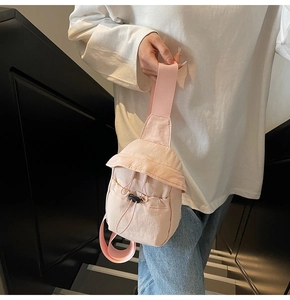 Detail of light pink nylon crossbody bag with elastic drawstring and wide shoulder strap
