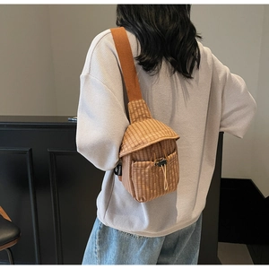 Brown plaid crossbody bag with drawstring flap and wide shoulder strap on model back