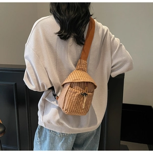 Detailed back view of a brown checkered crossbody bag with adjustable wide strap on model