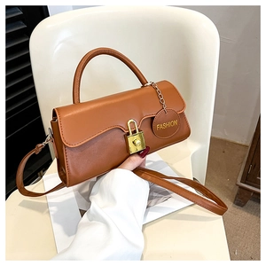 Détail du sac en cuir marron avec fermoir cadenas doré et pendentif de mode élégant