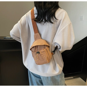 Close-up of brown plaid canvas crossbody bag featuring a drawstring front pocket and strap