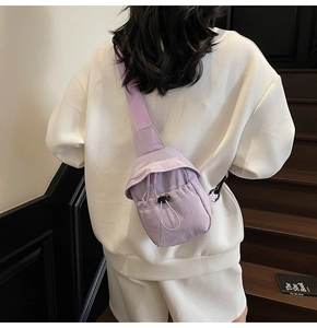 Detail of lavender nylon crossbody bag with drawstring pocket and adjustable strap