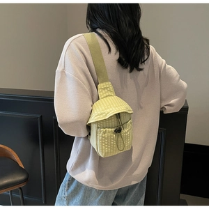 Detail of light green checkered mini crossbody bag with drawstring on back view