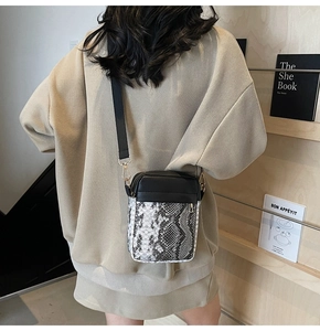 Detail of crossbody bag with snake print leather and adjustable wide shoulder strap
