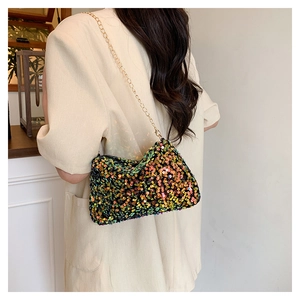Détail du sac à paillettes avec texture vert et or scintillante et bandoulière chaîne