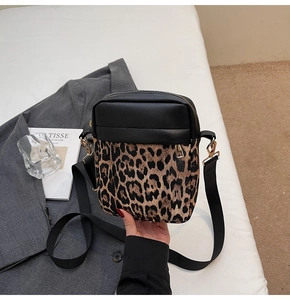 Close-up of small crossbody bag with leopard print, lychee grain leather, and gold hardware