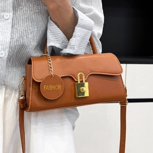 Sac bandoulière rétro marron en cuir avec cadenas doré et breloque sur mannequin femme