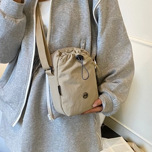 Beige nylon drawstring crossbody bag with adjustable wide strap for casual daily wear