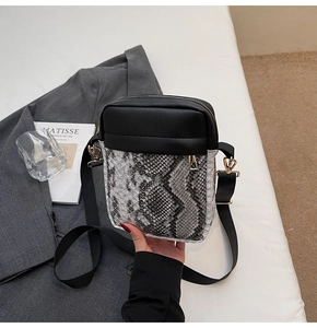 Detailed view of women's snake pattern crossbody bag with gold hardware and wide strap