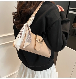 Dettaglio borsa baguette beige effetto coccodrillo con elegante sciarpa di seta stampata