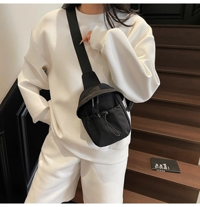Close-up of black nylon minimalist crossbody bag with adjustable drawstring and wide strap