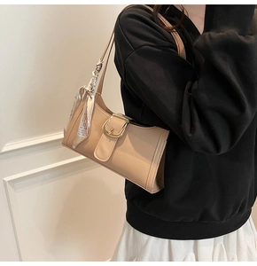 Dettaglio borsa beige effetto coccodrillo con fibbia dorata e foulard in seta chic