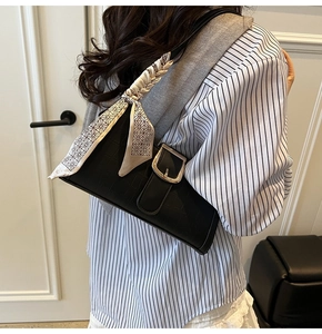 Dettaglio borsa baguette nera coccodrillo con fibbia dorata e foulard di seta