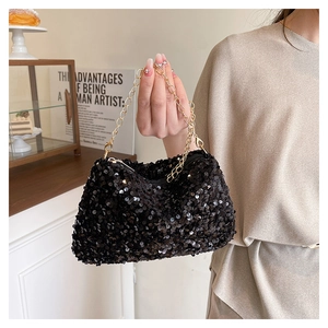 Vue détaillée de la texture des paillettes noires et de la fine chaîne dorée du petit sac chic