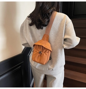 Detail of orange crossbody phone bag with adjustable drawstring on nylon fabric