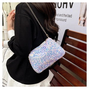 Mini sac bandoulière à paillettes irisées avec chaîne dorée porté par un mannequin