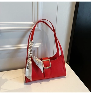 Détail du sac rouge gaufré croco avec un foulard en soie décoratif sur la bandoulière