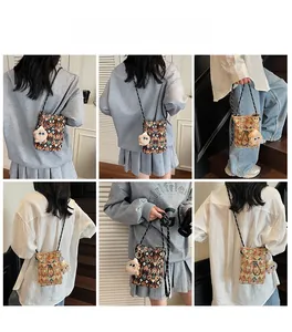 Detailed views of a geometric patterned mini crossbody bag with a plush charm accessory