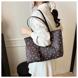 Detail of floral tote bag set with matching small zipper pouch worn by a model