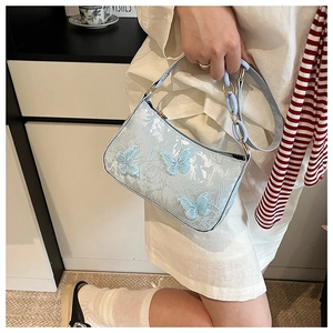 Detail of light blue jacquard tote bag featuring elegant 3D mesh butterfly appliques