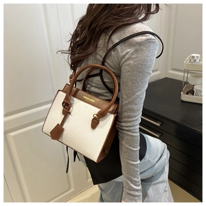 Detail of vintage square crossbody bag with contrast brown leather trim and lychee texture
