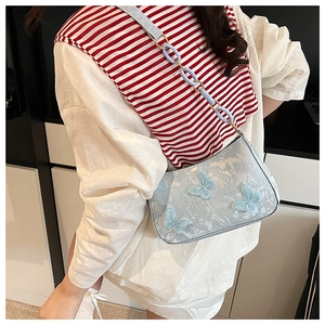 Detail of light blue tote bag with delicate butterfly embroidery and textured fabric