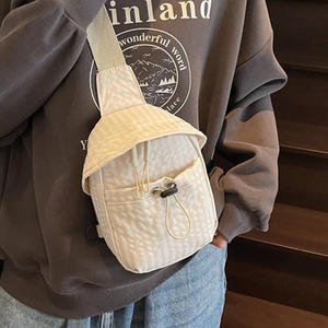 Minimalist cream textured crossbody bag with drawstring pocket on a side profile view