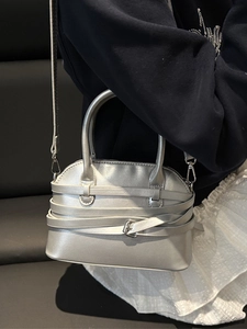 Borsa a mano argentata a forma di conchiglia con cinturini incrociati e fibbia in metallo