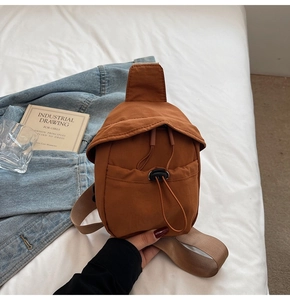 Caramel nylon crossbody bag detail with drawstring closure on a casual lifestyle setting