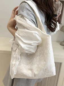 White lace floral tote bag with elegant ruffle trim shown on model for daily commute