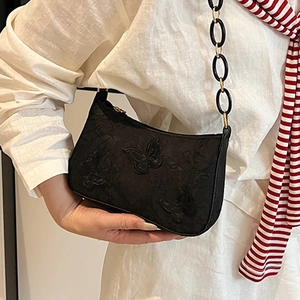 Modern black hobo tote bag with 3D butterfly texture and gold hardware on model
