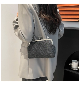 Détail du sac à paillettes noir avec fermoir vintage en métal et bandoulière chaîne